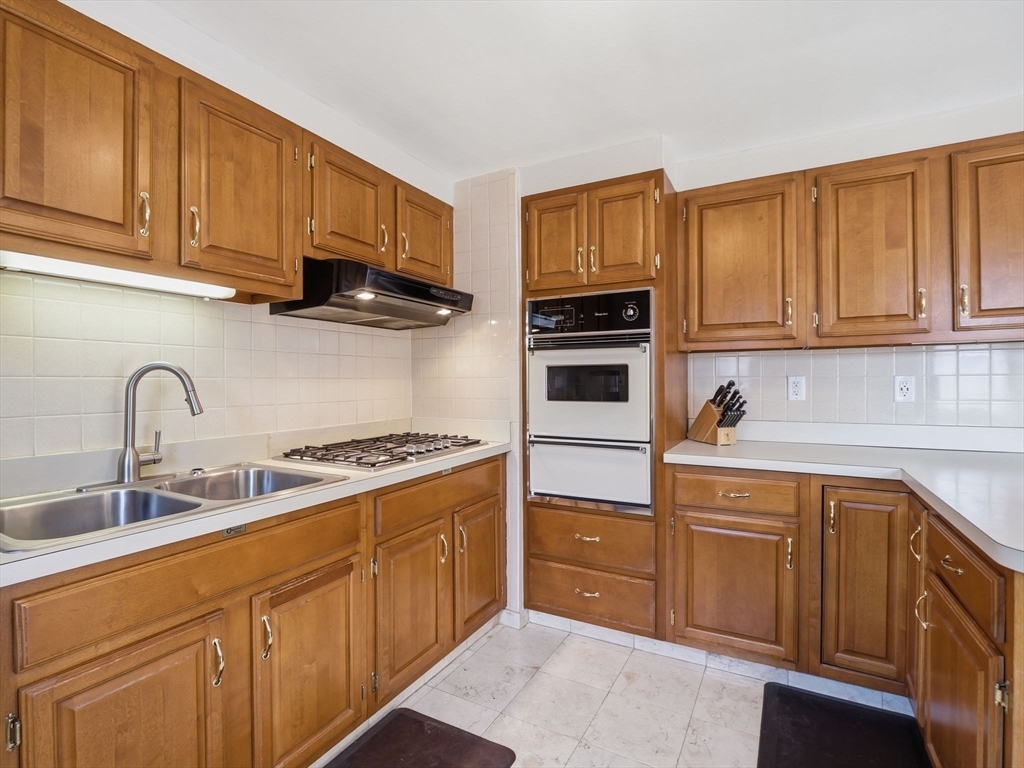 34 Beaconsfield Street Lawrence, MA 01843 - Photo 13 of 29 a kitchen with stainless steel appliances granite countertop a sink stove and cabinets