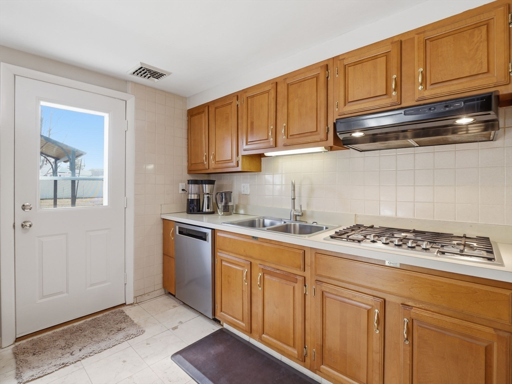 34 Beaconsfield Street Lawrence, MA 01843 - Photo 15 of 29 a kitchen with stainless steel appliances granite countertop a sink stove and cabinets