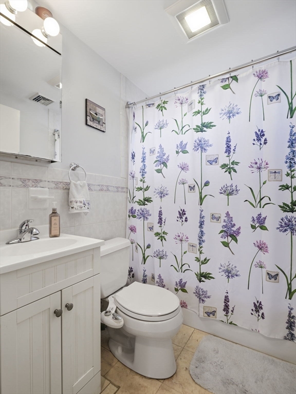 34 Beaconsfield Street Lawrence, MA 01843 - Photo 22 of 29 a bathroom with a toilet and a sink a mirror a shower curtain