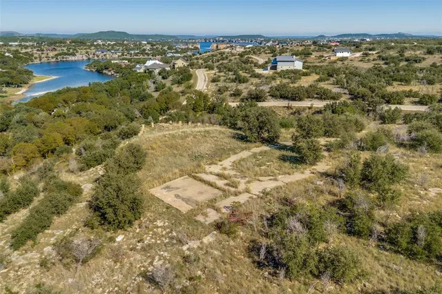 an aerial view of residential houses with outdoor space and trees