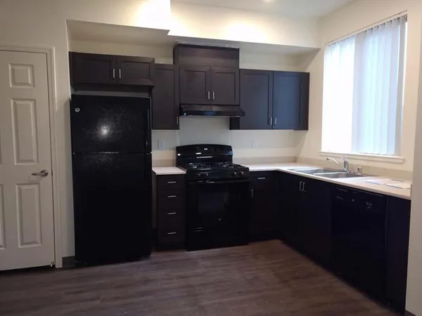 a kitchen with granite countertop stainless steel appliances and wooden cabinets