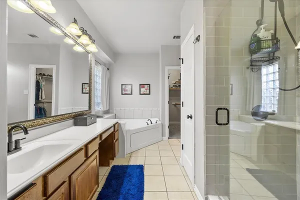 a spacious bathroom with a granite countertop sink mirror and shower