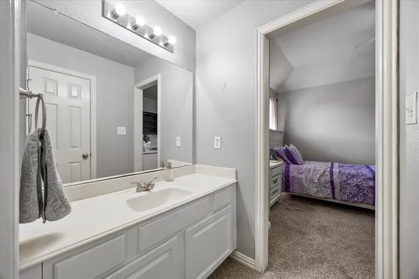 a en suite bathroom with a double vanity sink and a mirror