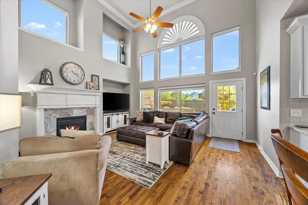 a living room with furniture a fireplace and a floor to ceiling window