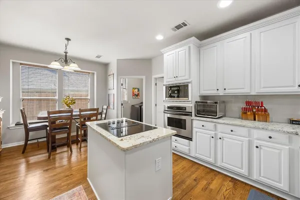 a kitchen that has a lot of cabinets in it and stainless steel appliances