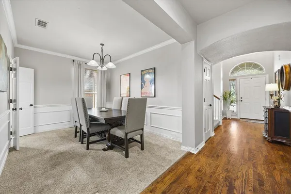 a view of a dining room with furniture and a chandelier