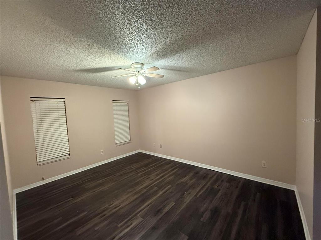 5411 Myrica Road Orlando, FL 32810 - Photo 20 of 26 an empty room with wooden floor and windows
