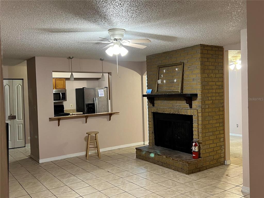 5411 Myrica Road Orlando, FL 32810 - Photo 8 of 26 a living room with fireplace and a flat screen tv