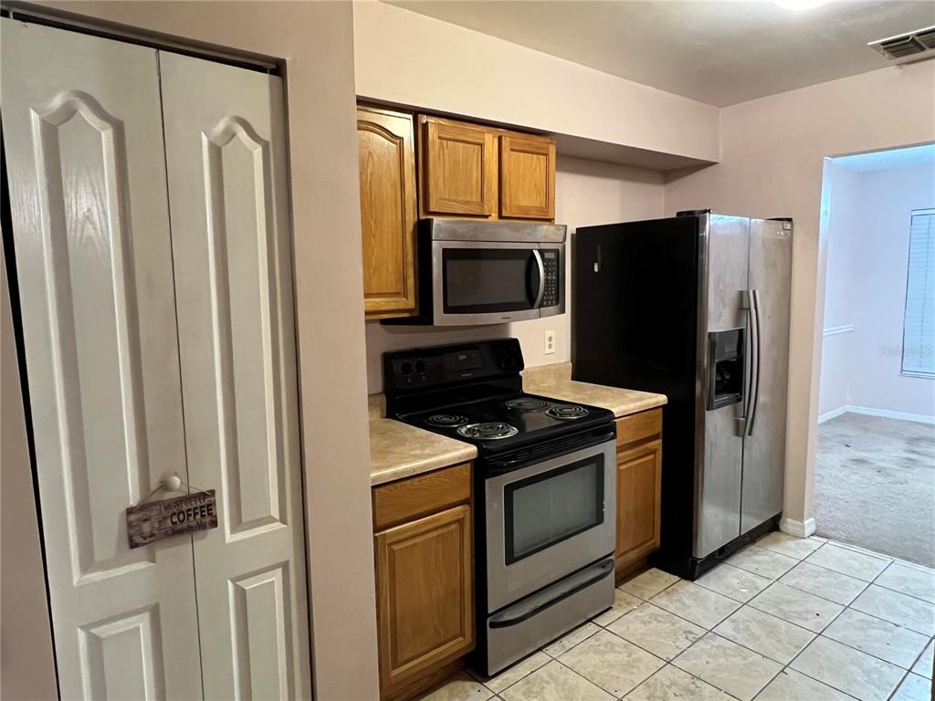 5411 Myrica Road Orlando, FL 32810 - Photo 10 of 26 a kitchen with a refrigerator stove and microwave