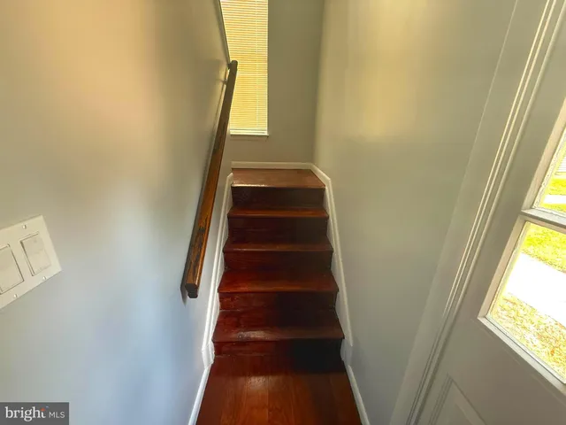 a view of staircase with wooden floor and white walls
