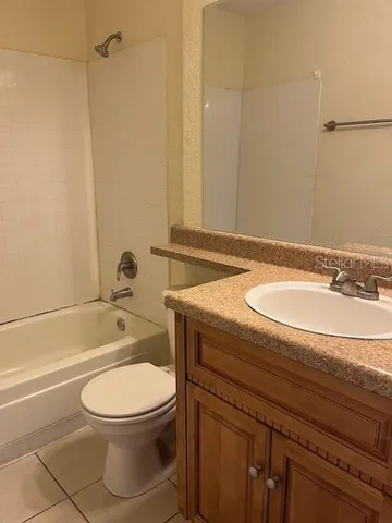 a bathroom with a granite countertop toilet a sink and bathtub