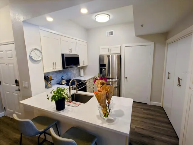a kitchen with a dining table cabinets and appliances