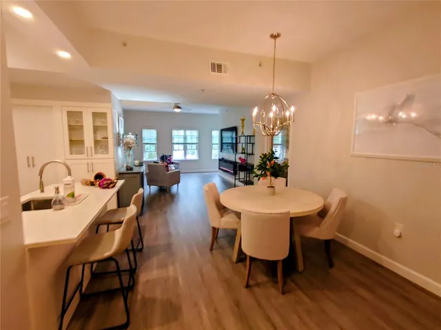 a dining room with furniture a chandelier and wooden floor