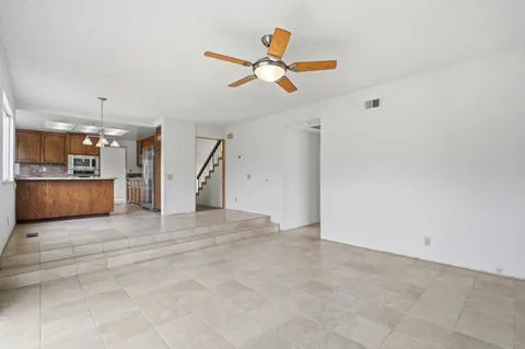 a view of a livingroom with a ceiling fan and kitchen view