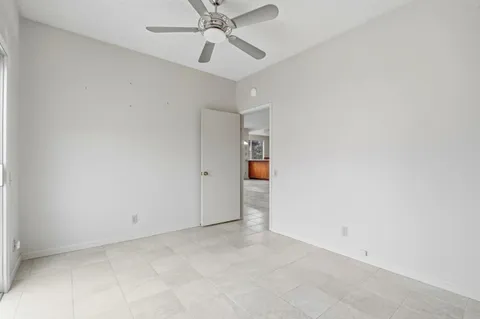 an empty room with a ceiling fan and carpet
