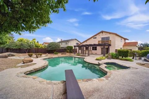 a view of backyard with swimming pool and seating space