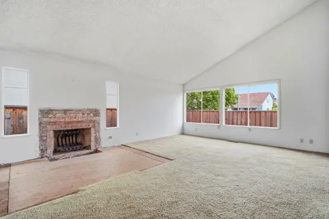an empty room with fireplace and window