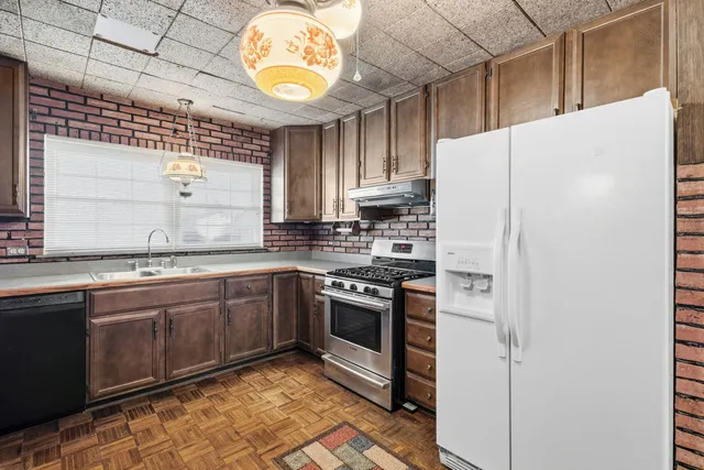 a kitchen with stainless steel appliances granite countertop a sink a stove a refrigerator and island