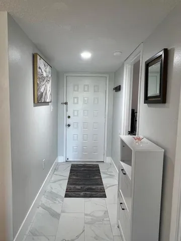a living room with furniture a dining table and a refrigerator