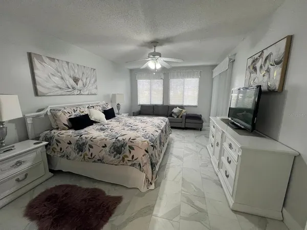 a bedroom with a large bed and a flat tv screen on a dresser