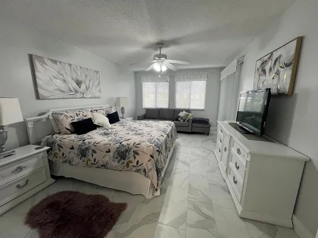 a bedroom with a large bed and a flat tv screen on a dresser