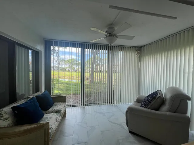 a living room with furniture and a floor to ceiling window