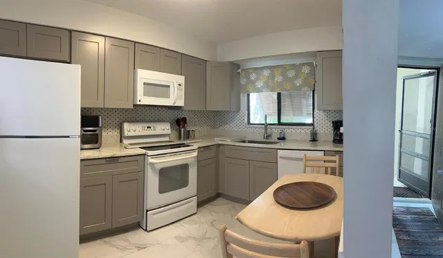 a kitchen with a refrigerator a sink and a stove top oven