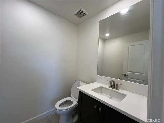 a bathroom with a granite countertop sink a toilet and a mirror