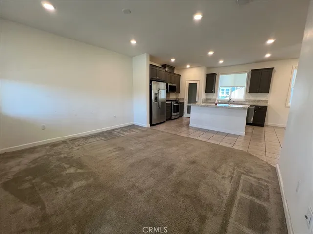 a large room with kitchen island a sink a large window and a counter top space