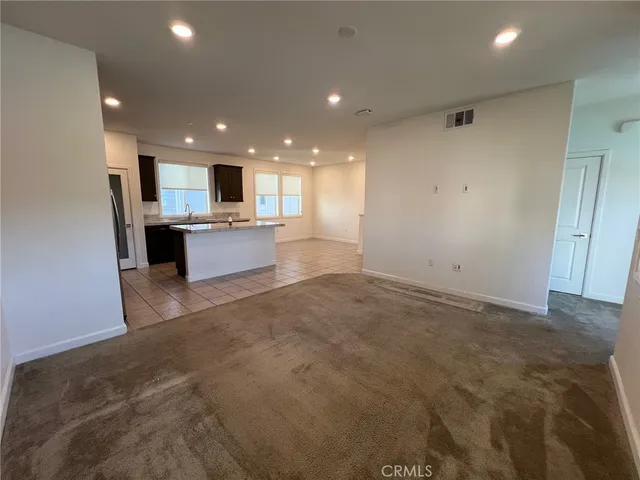 a view of a kitchen with kitchen island a sink wooden floor and counter top space