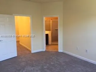 an empty room with an entryway and a window