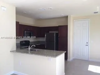 a kitchen with stainless steel appliances granite countertop a sink refrigerator and cabinets