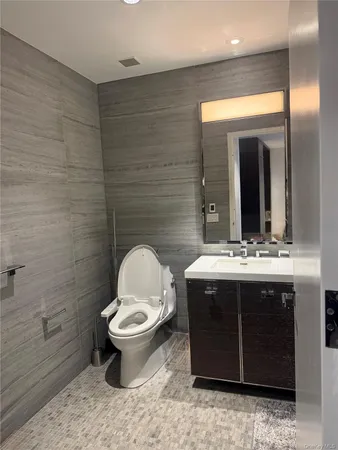 a bathroom with a granite countertop toilet sink and mirror