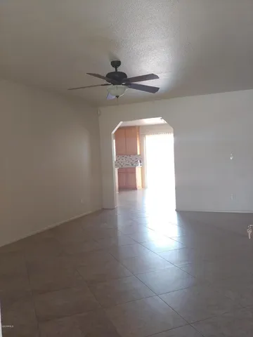 a view of a hallway with a ceiling fan and wooden floor