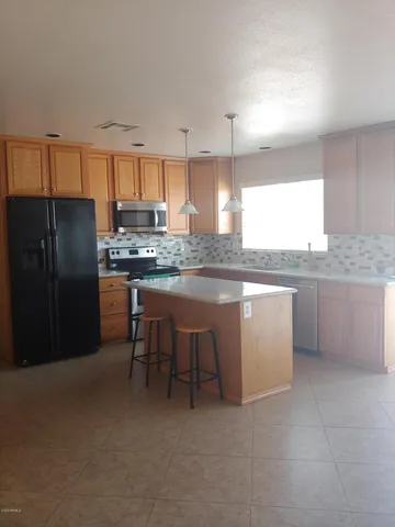 a kitchen with stainless steel appliances granite countertop a stove refrigerator sink and cabinets
