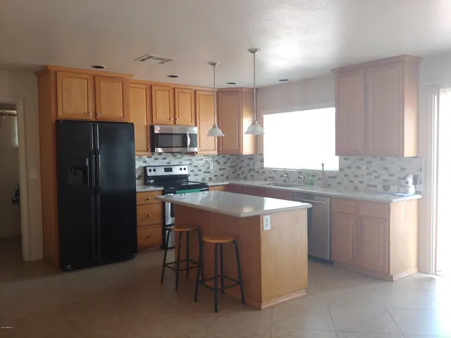 a kitchen with stainless steel appliances granite countertop a stove refrigerator sink and cabinets