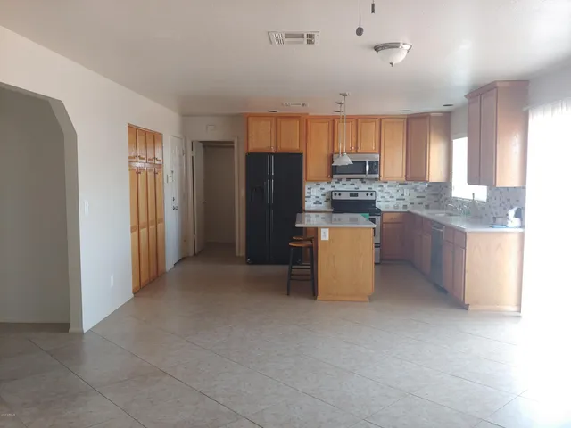 a kitchen with stainless steel appliances granite countertop a refrigerator and a stove top oven