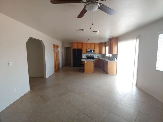 a view of a kitchen with kitchen island stainless steel appliances a sink a counter top space cabinets and a window