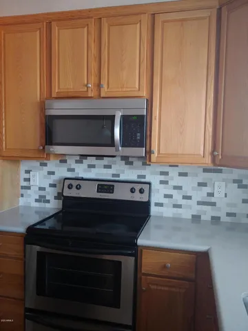 a kitchen with granite countertop a stove microwave and cabinets
