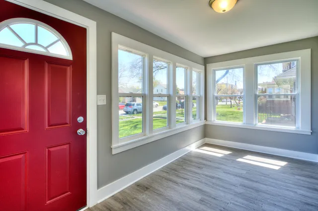 a view of hallway with a large window and wooden floor