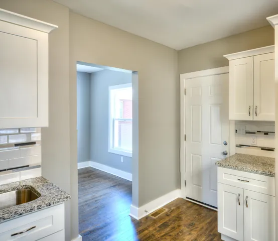 a kitchen with a refrigerator and white cabinets