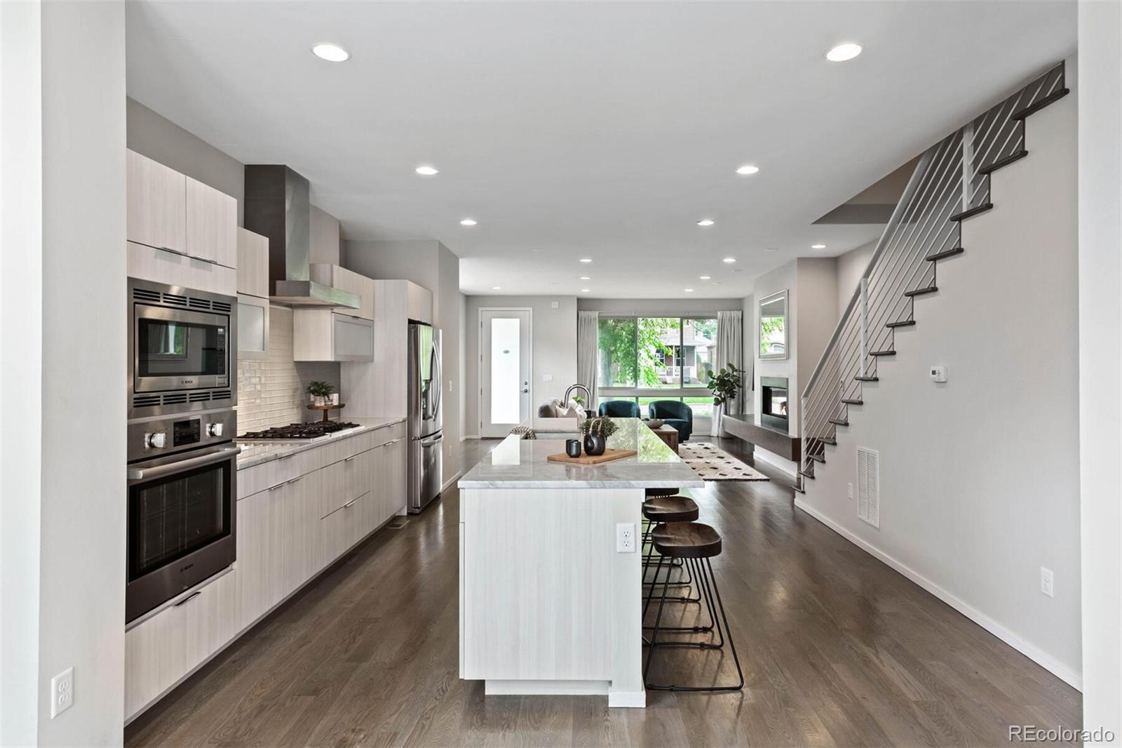 4011 Raleigh Street Denver, CO 80212 - Photo 13 of 34 a kitchen with stainless steel appliances kitchen island granite countertop a stove a sink a refrigerator and white cabinets with wooden floor
