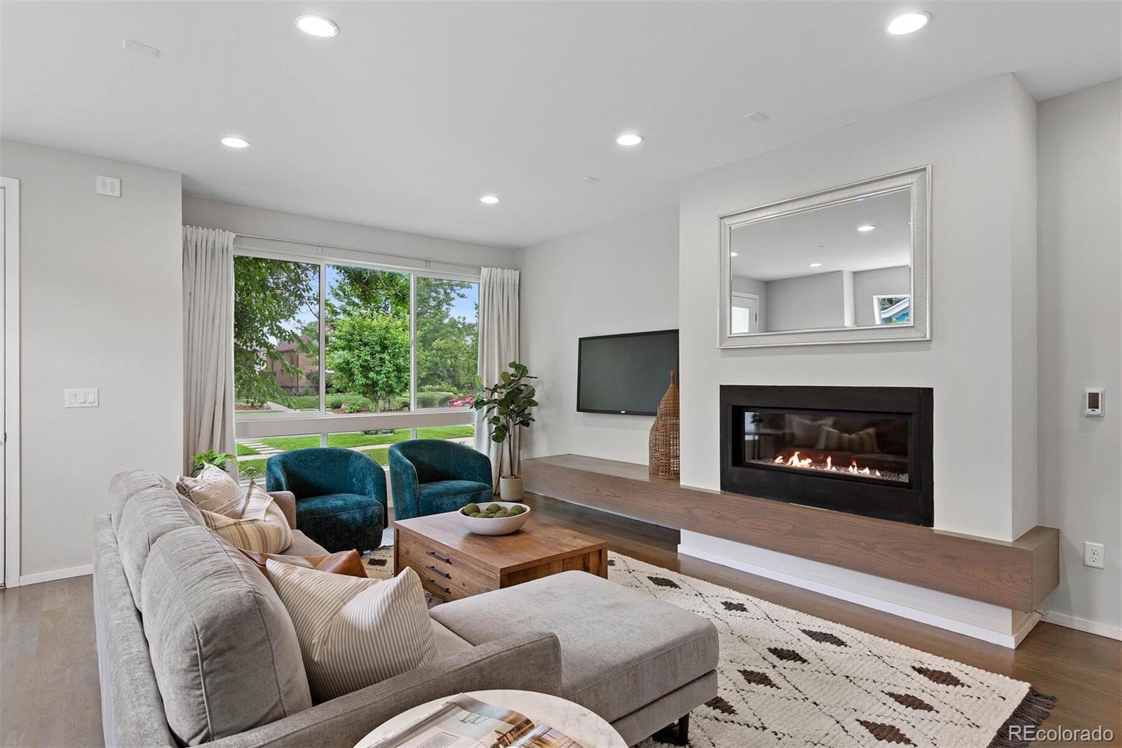 4011 Raleigh Street Denver, CO 80212 - Photo 6 of 34 a living room with furniture a large window and a fireplace