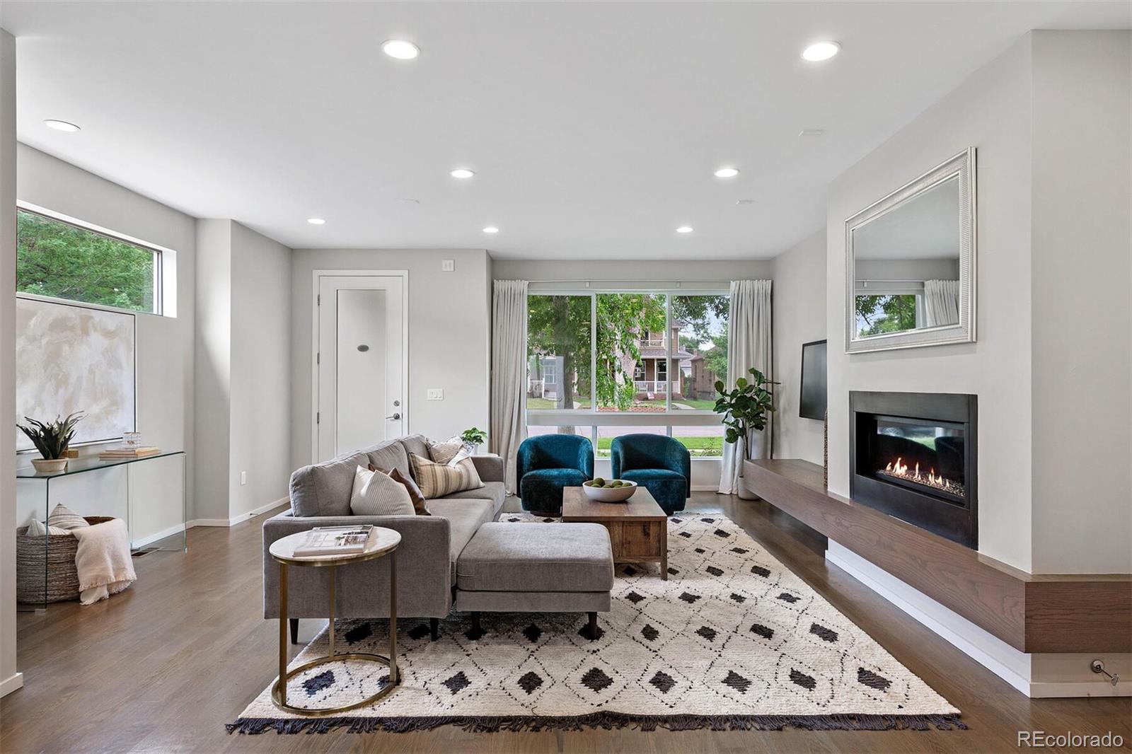 4011 Raleigh Street Denver, CO 80212 - Photo 7 of 34 a living room with furniture a rug a fireplace and a large window