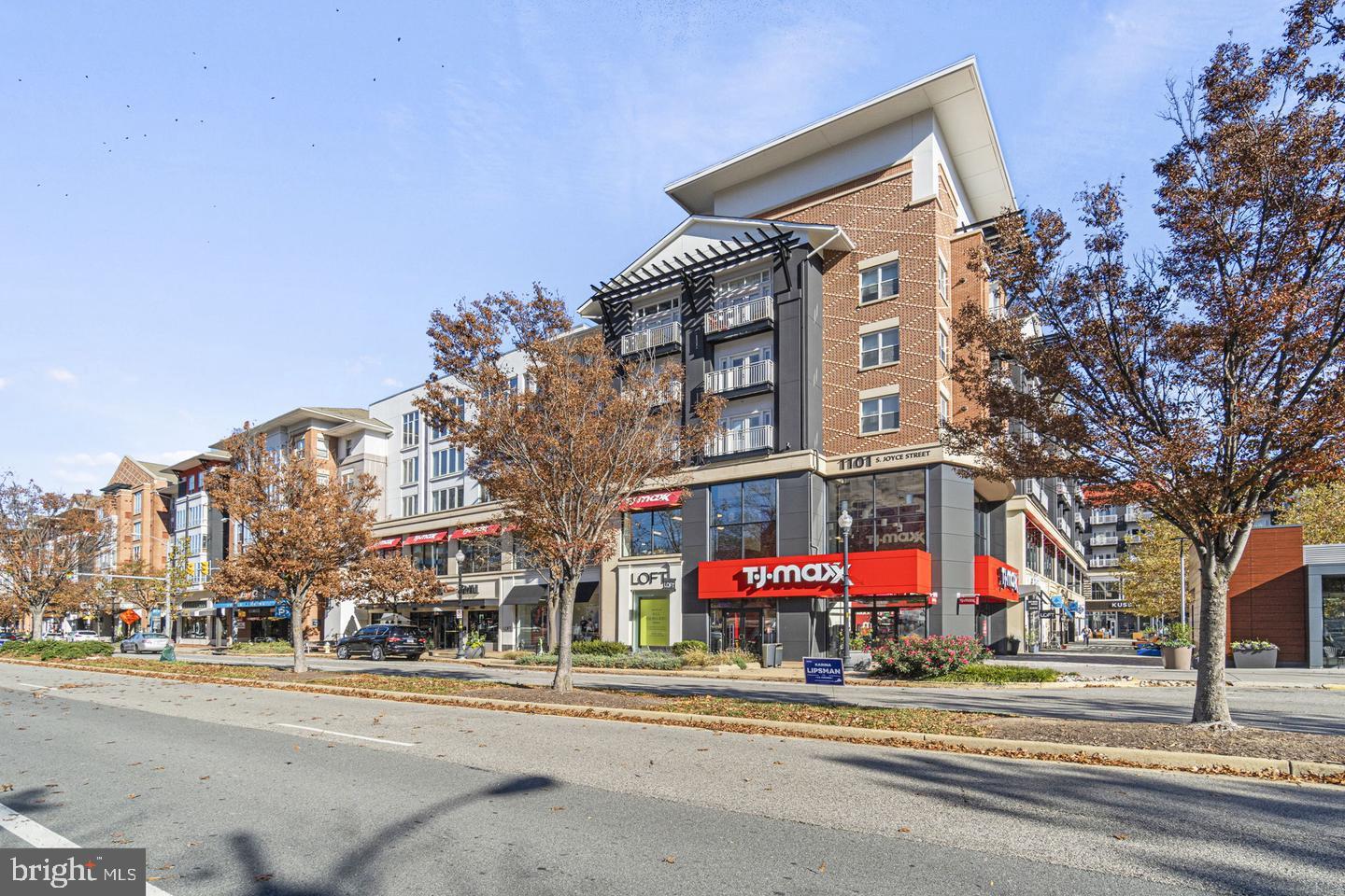 1300 Army Navy Drive, Unit 104 Arlington, VA 22202 - Photo 15 of 19 a front view of multi story residential apartment building with yard and traffic signal