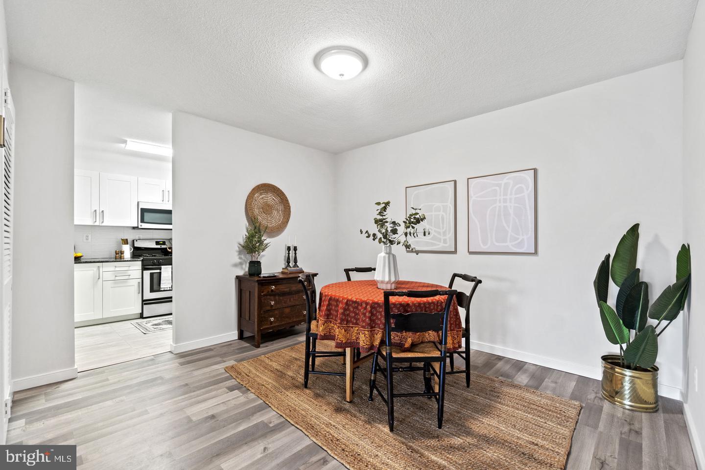 1300 Army Navy Drive, Unit 104 Arlington, VA 22202 - Photo 6 of 19 a view of a dining room with furniture and wooden floor