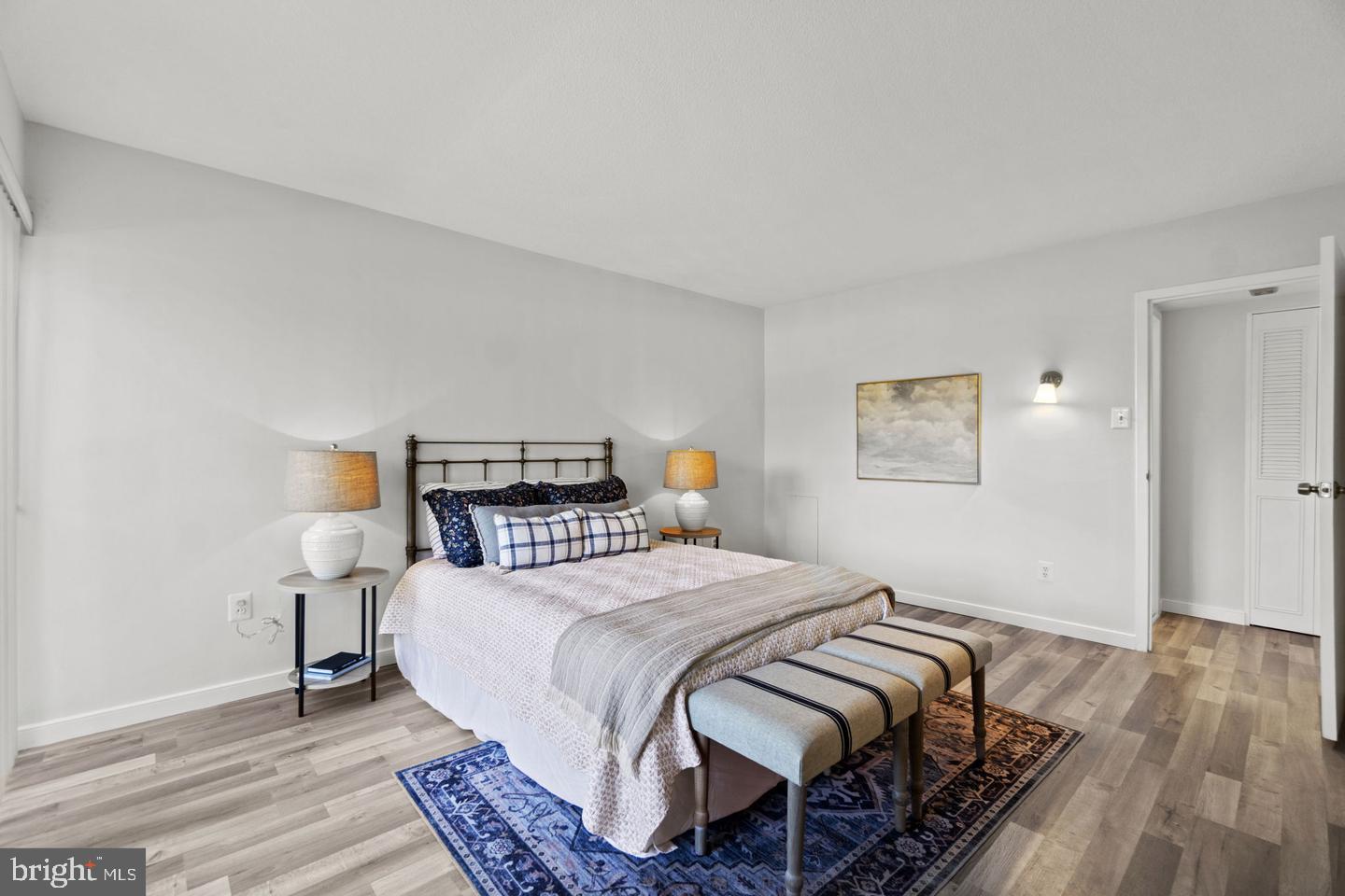 1300 Army Navy Drive, Unit 104 Arlington, VA 22202 - Photo 8 of 19 a bedroom with a bed and wooden floor