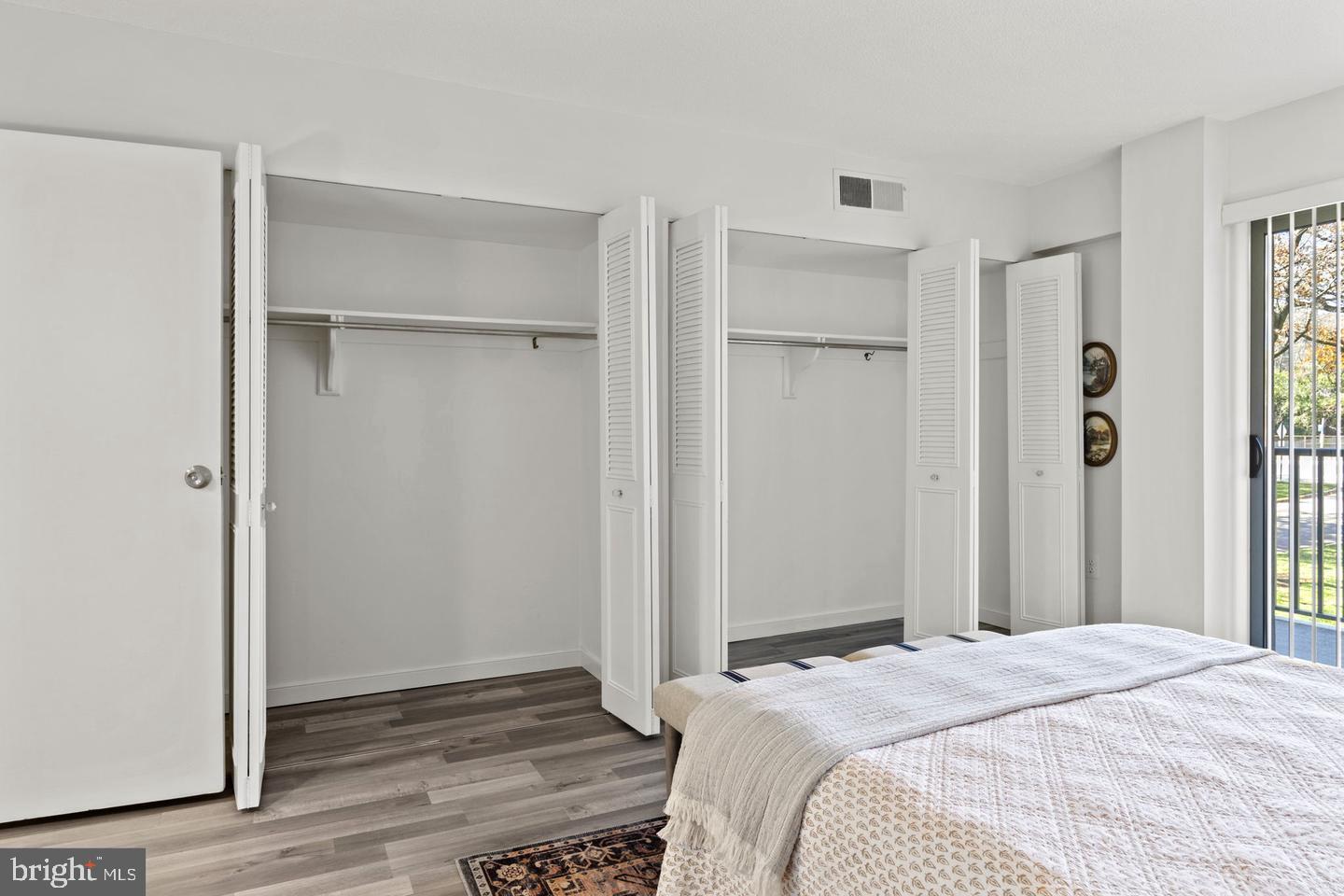 1300 Army Navy Drive, Unit 104 Arlington, VA 22202 - Photo 10 of 19 a bedroom with a bed and wooden floor