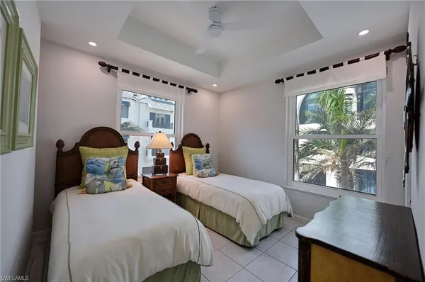 a bedroom with two beds and a large window