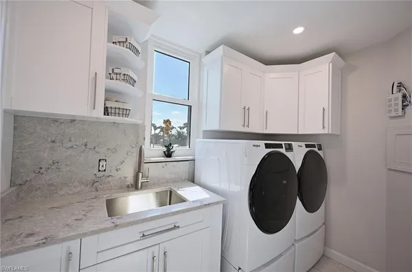 a utility room with sink dryer and washer